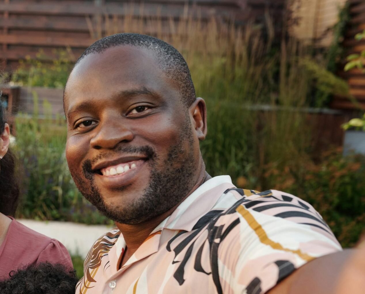 Smiling multicultural family enjoying time together outdoors in their garden.